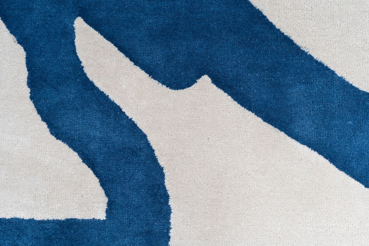 Bedlam Wool Rug close up, ivory hand tufted New Zealand wool with broad loose strokes of deep blue.