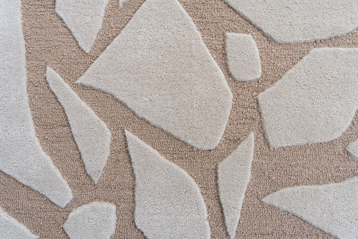 Bergamo Rug close up, hand tufted New Zealand wool with soft ivory shapes on a warm sand ground.