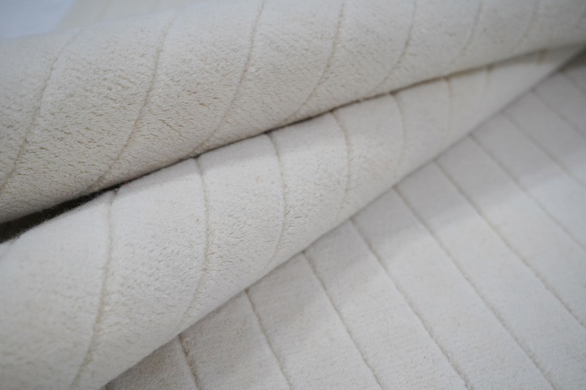 Bitte Wool Rug folded, ivory hand tufted New Zealand wool with fine tone on tone lines.