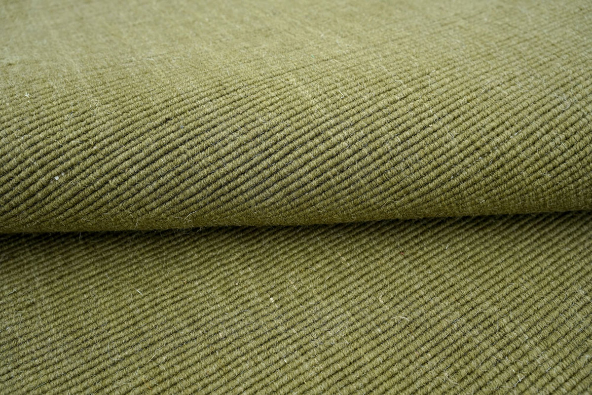 Cabra Wool & Jute Rug in Olive folded, a firm handloom weave of New Zealand wool and jute.