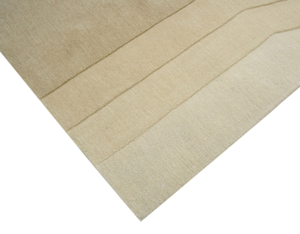 Cadence Wool Rug folded at the edge, hand tufted ivory New Zealand wool with stepped carved bands.