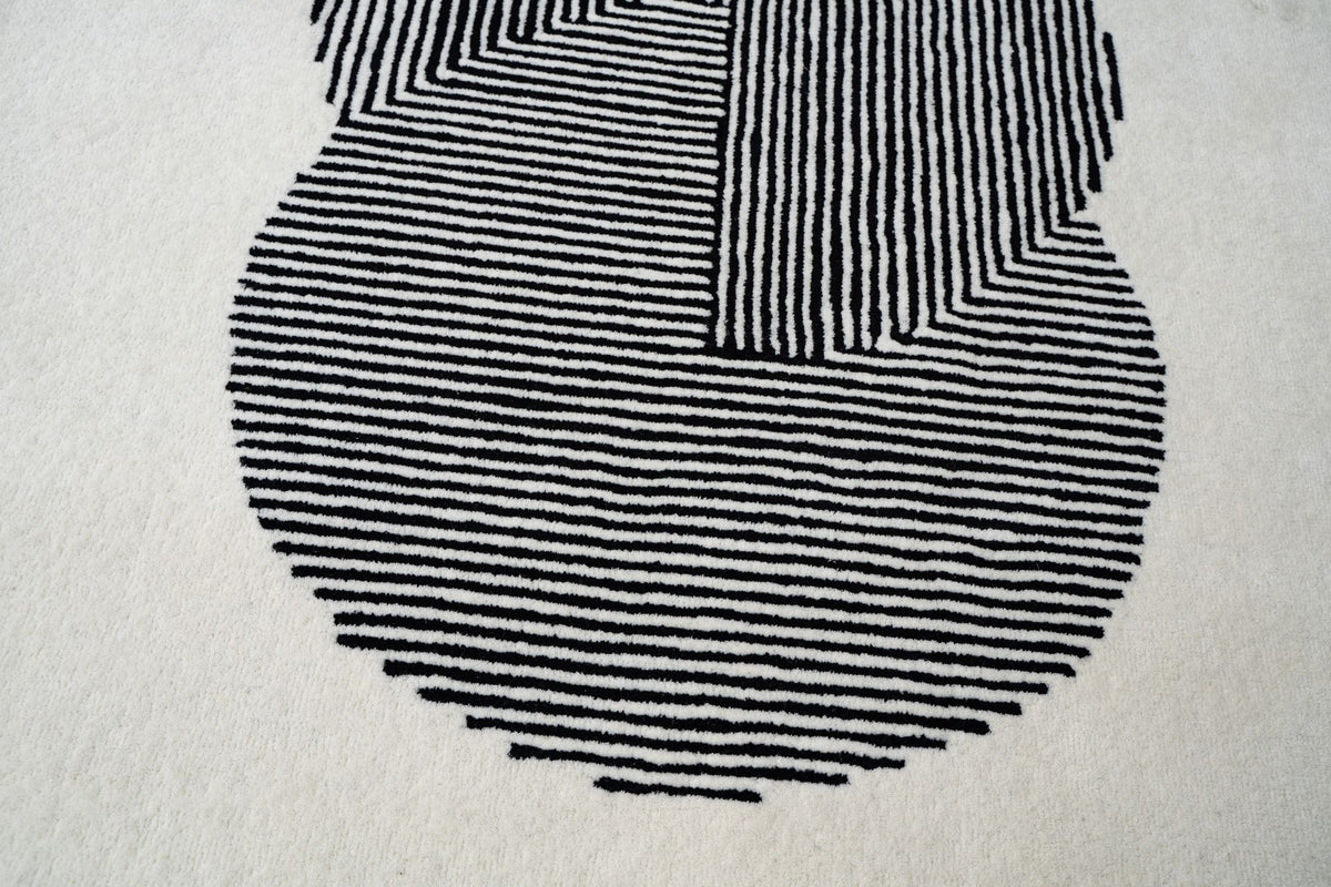 Clique Wool Rug in Bone White close up, clustered black lines on a pale hand tufted New Zealand wool ground.