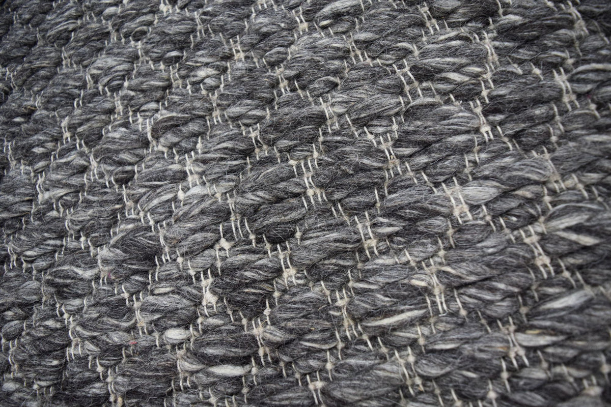 Cobble Wool Rug close up, a firm handwoven New Zealand wool in charcoal and grey with a raised pebble texture.