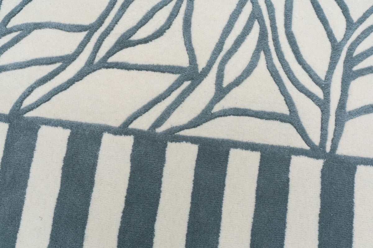 Euphoric Wool Rug close up, a hand tufted New Zealand wool rug with branching blue lines over blue and ivory stripes.