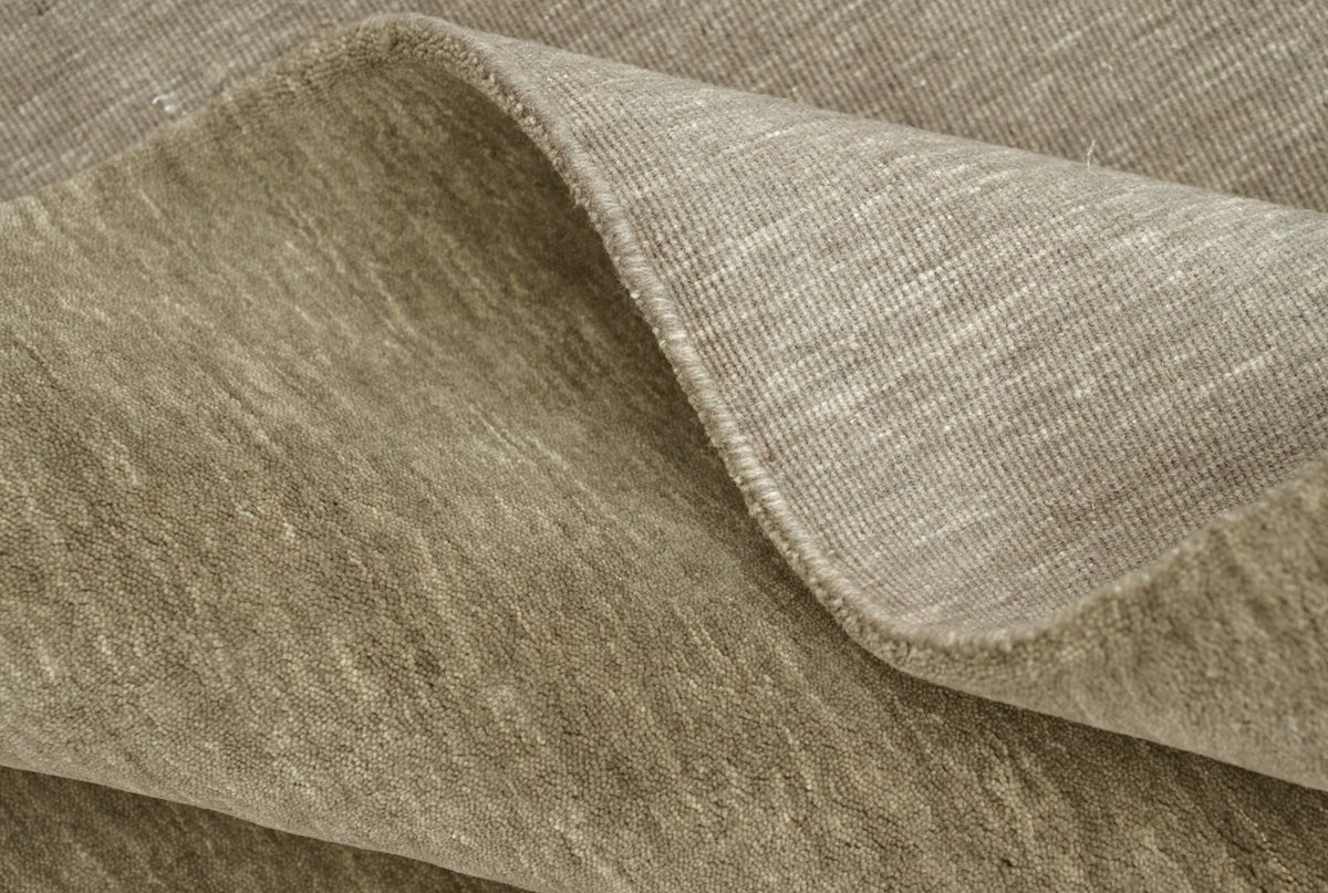 Grain Wool Rug in Sage turned back at the edge, handloom New Zealand wool in a grey leaning green.