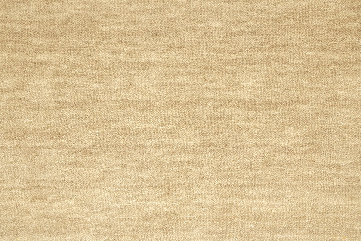 Grain Wool Rug in Sandstone close up, a natural sand tone that softens towards itself in strong light.