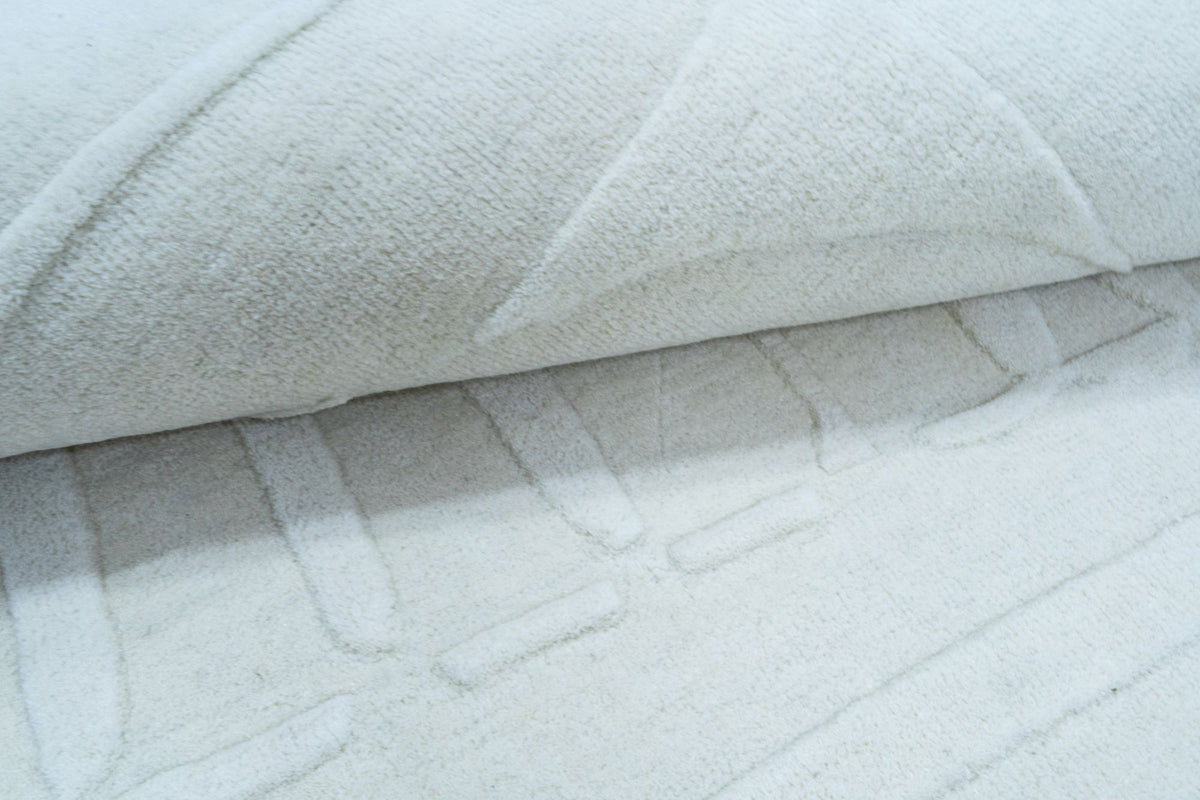 Ivory Wool Rug close up, handloom New Zealand wool in a soft ivory, folded to show the depth of the pile.