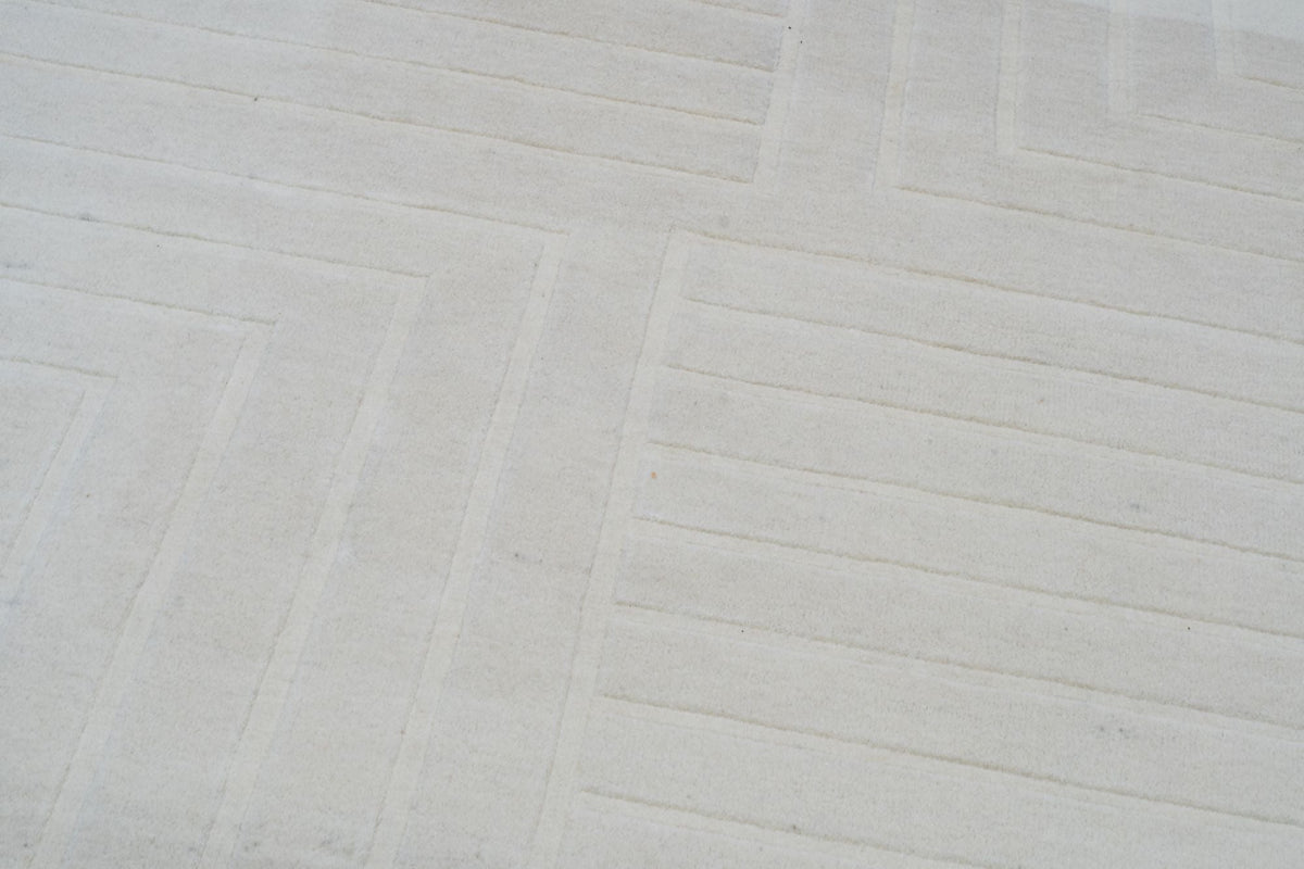 Liner Wool Rug close up, cream hand tufted New Zealand wool with fine carved lines.