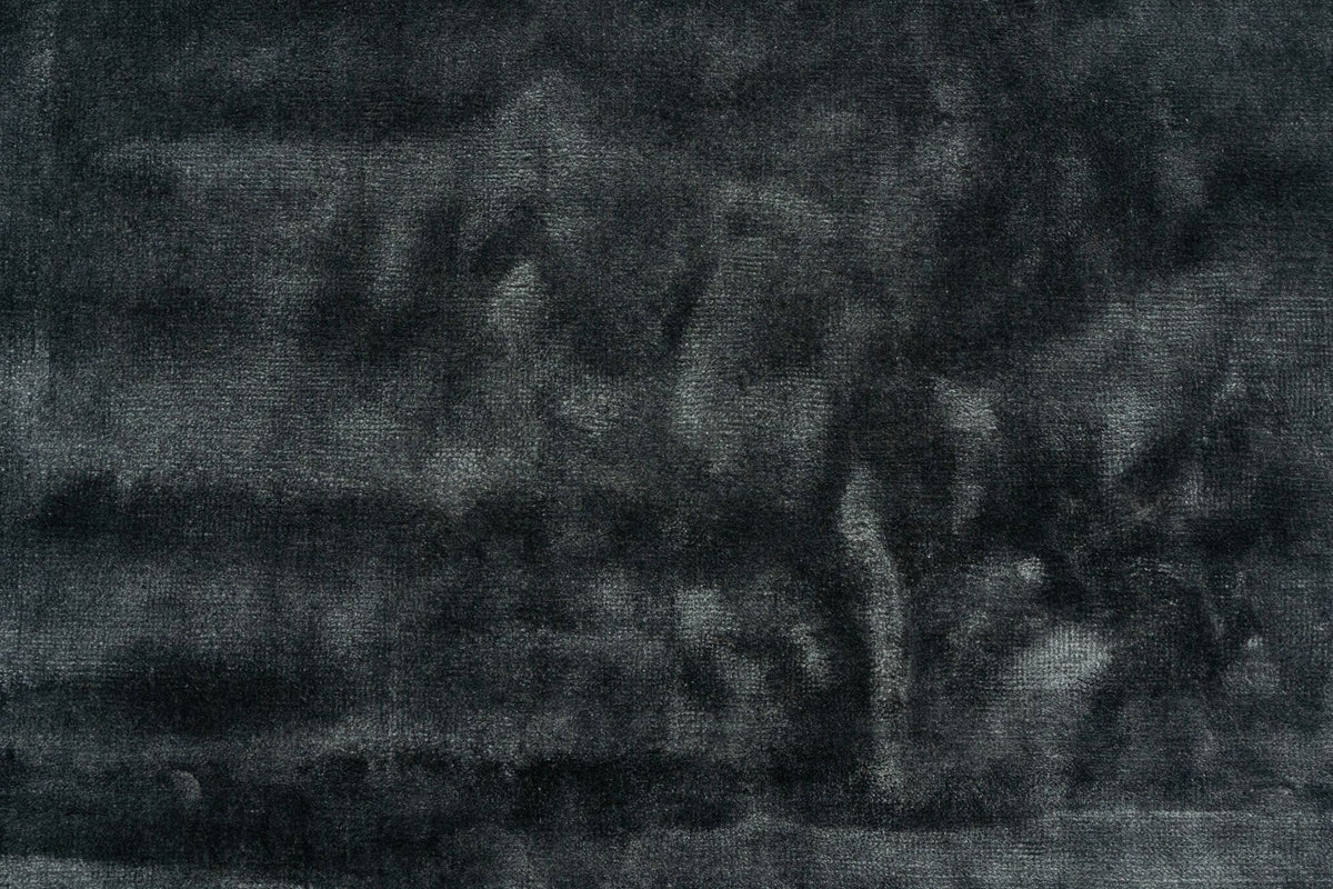 Luma Silk Rug in Charcoal close up, handloom Botanical Silk with a soft sheen moving across the dark pile.