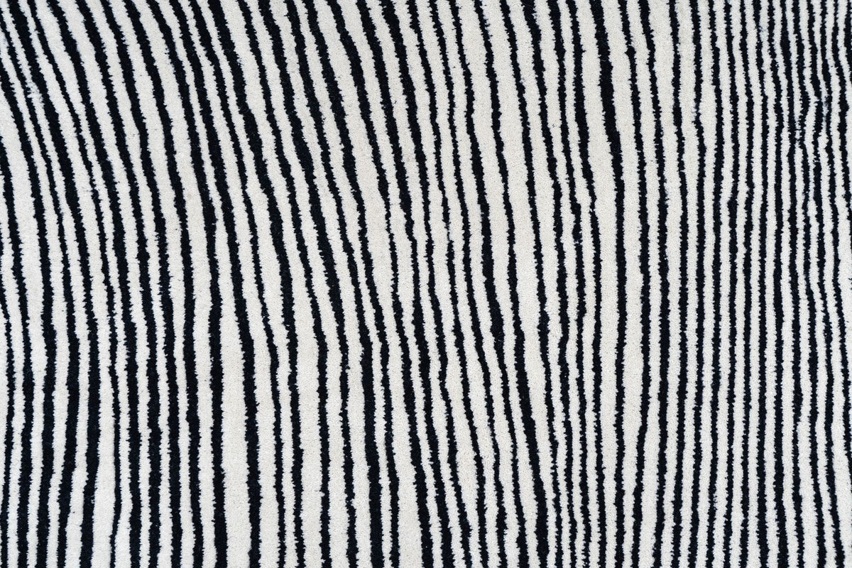 Monochrome Wool Rug close up, black and ivory lines of hand tufted New Zealand wool, each colour running through the full depth of the pile.