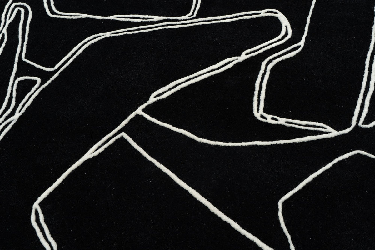 Mosaic Wool Rug close up, hand tufted black New Zealand wool drawn with fine ivory lines.