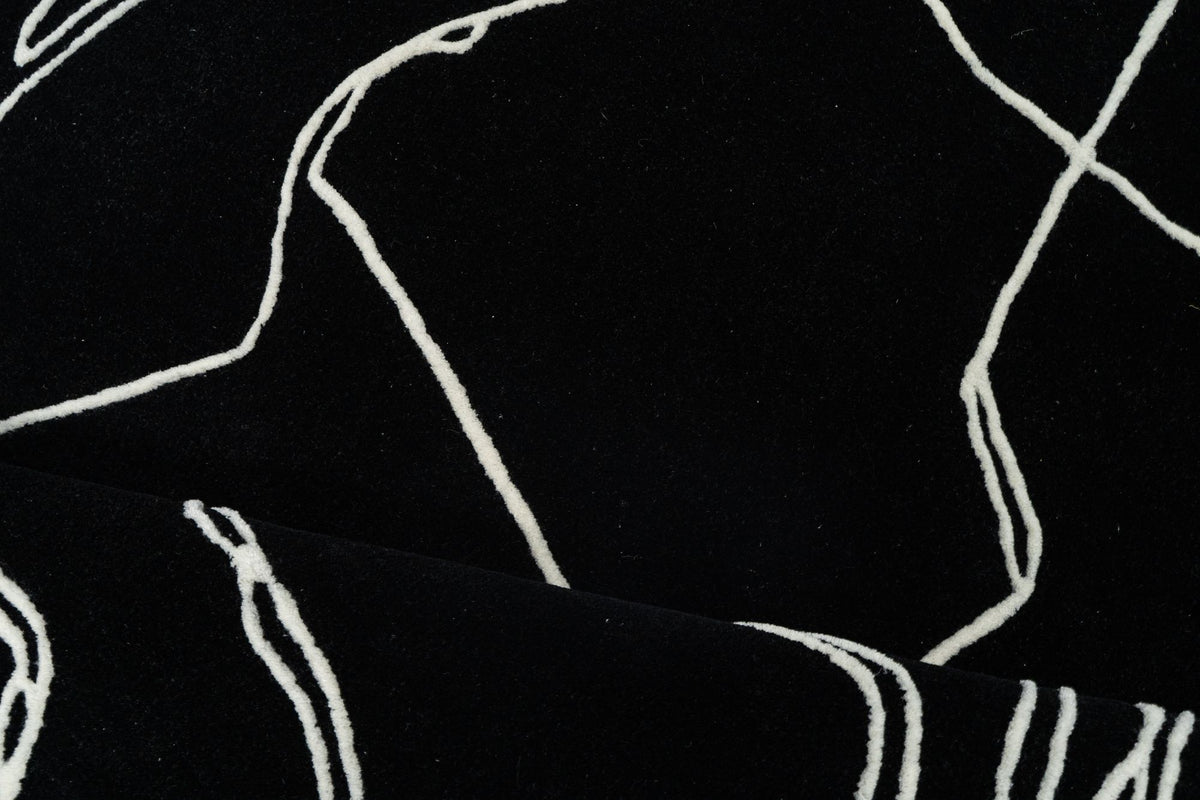 Mosaic Wool Rug close up, hand tufted New Zealand wool with fine ivory lines drawn across a black field.