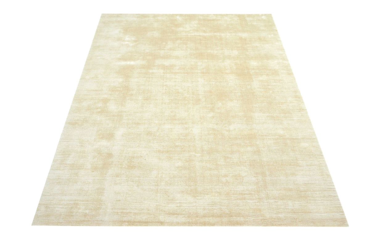 Nuva Silk Rug in Beige, handloom Botanical Silk laid flat, its sheen running in pale streaks across the surface.