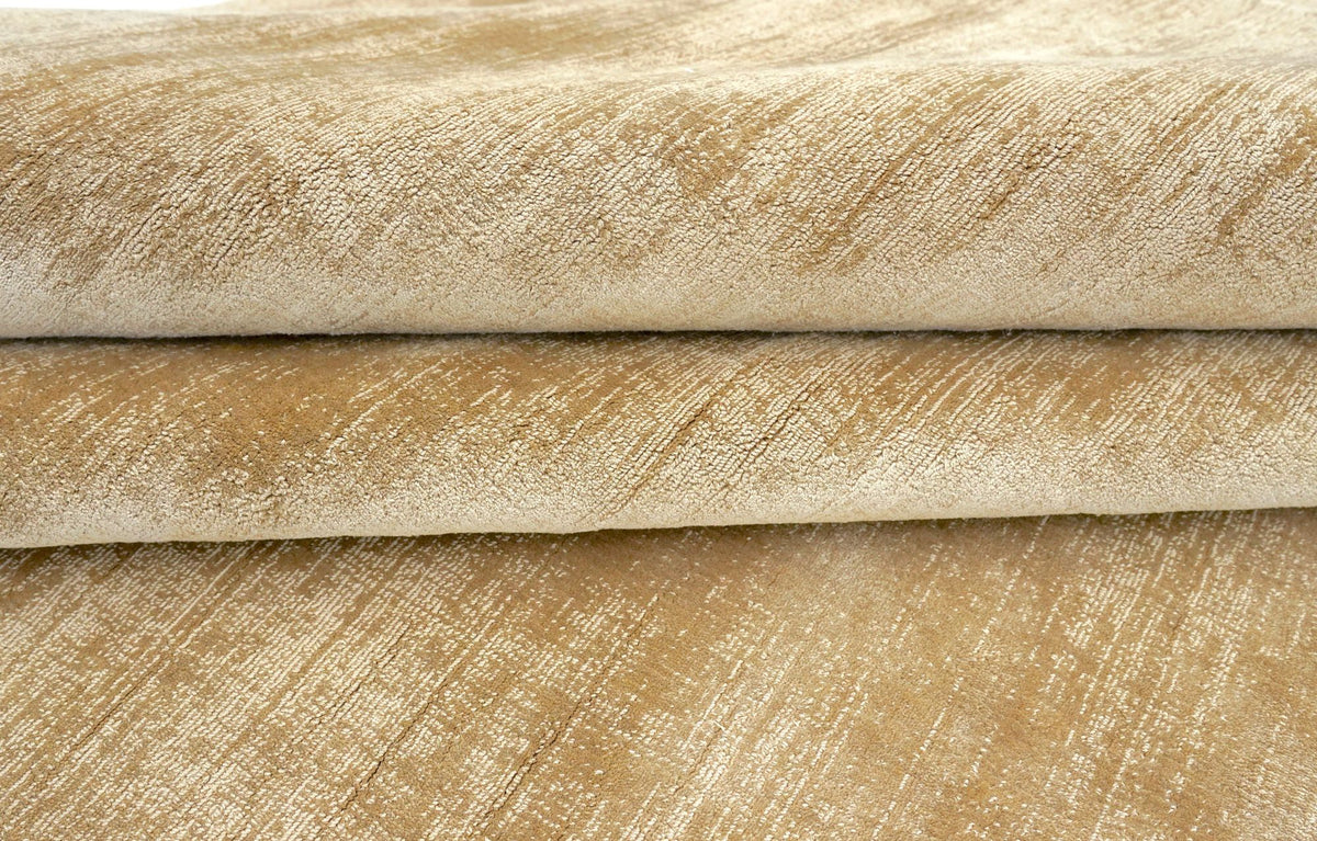 Nuva Silk Rug in Camel folded at the edge, handloom Botanical Silk with a warm golden sheen.