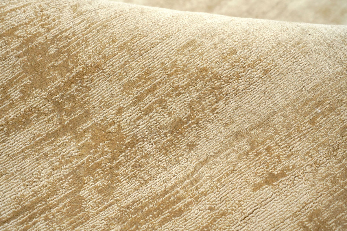 Nuva Silk Rug in Camel close up, handloom Botanical Silk with a soft, uneven sheen in warm gold and sand.