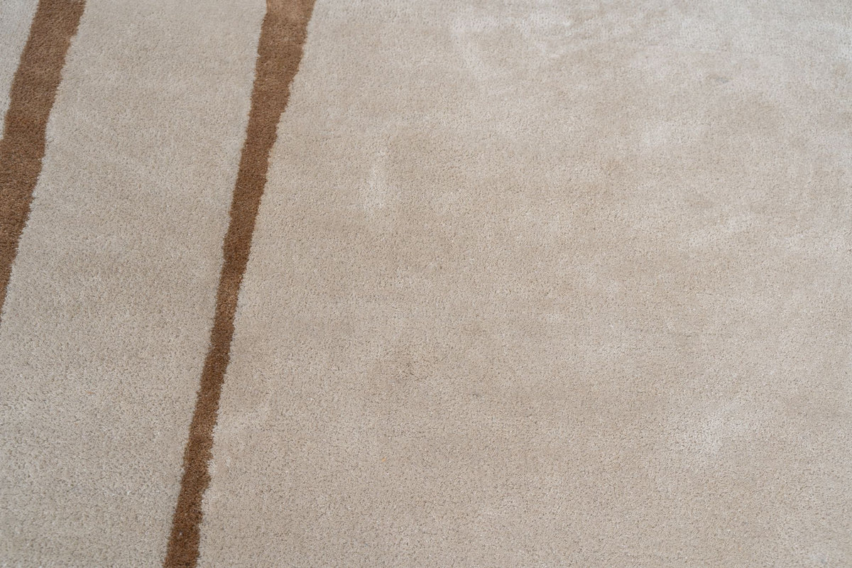 Outline Wool Rug close up, a camel line drawn across an open ivory field of hand tufted New Zealand wool.