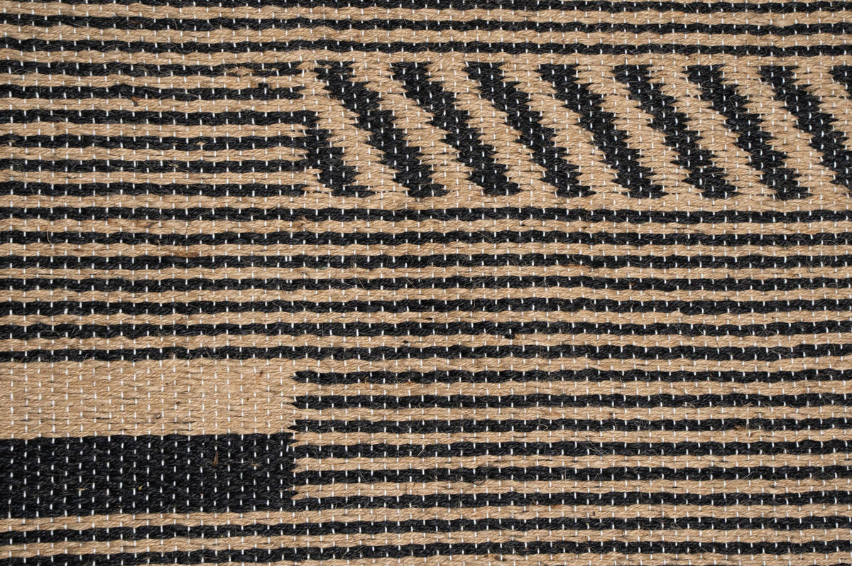 Pampas Jute Rug close up, handwoven jute in natural and black with blocks of diagonal stripes.