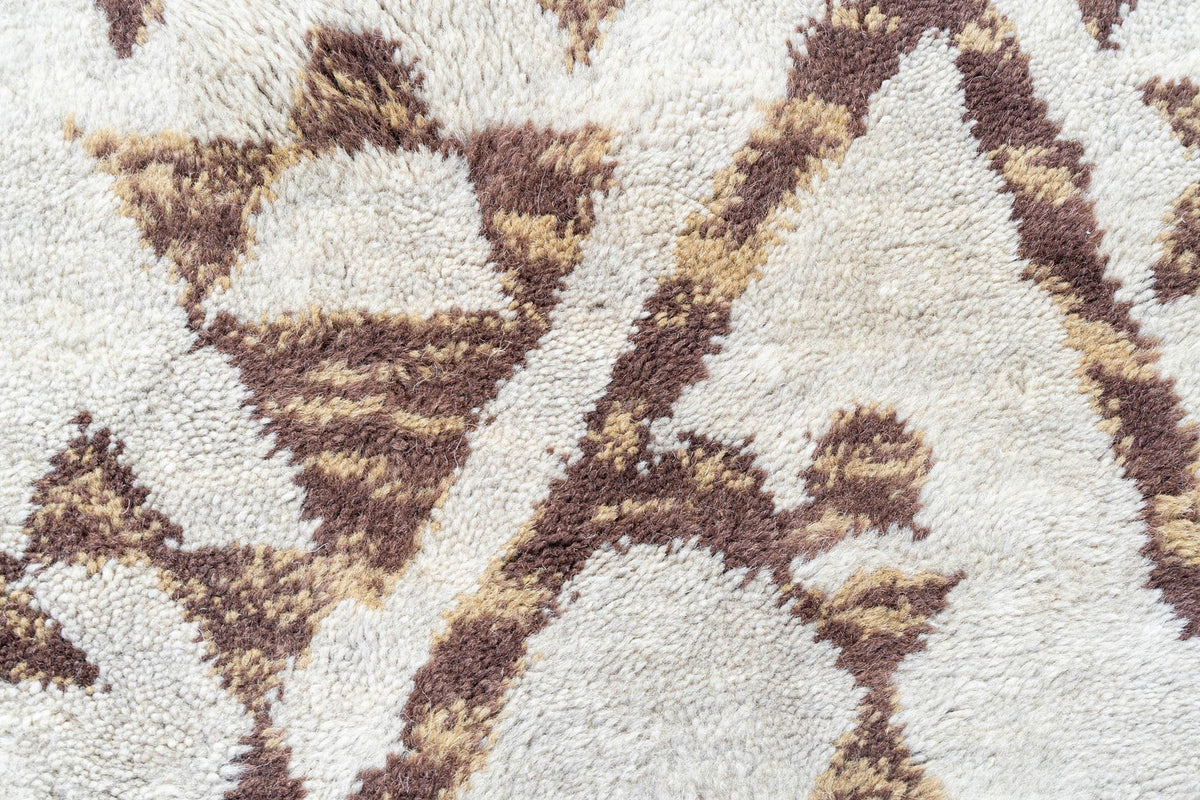 Pearl Fold Wool Rug close up, hand tufted ivory New Zealand wool with brown and gold motifs in a soft, lofty pile.