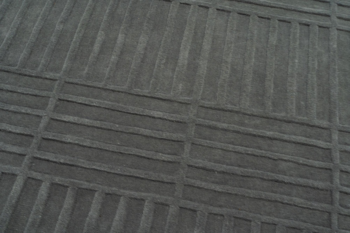 Plaid Rug close up, hand tufted New Zealand wool in a deep grey green, crossed with carved lines in a soft plaid.