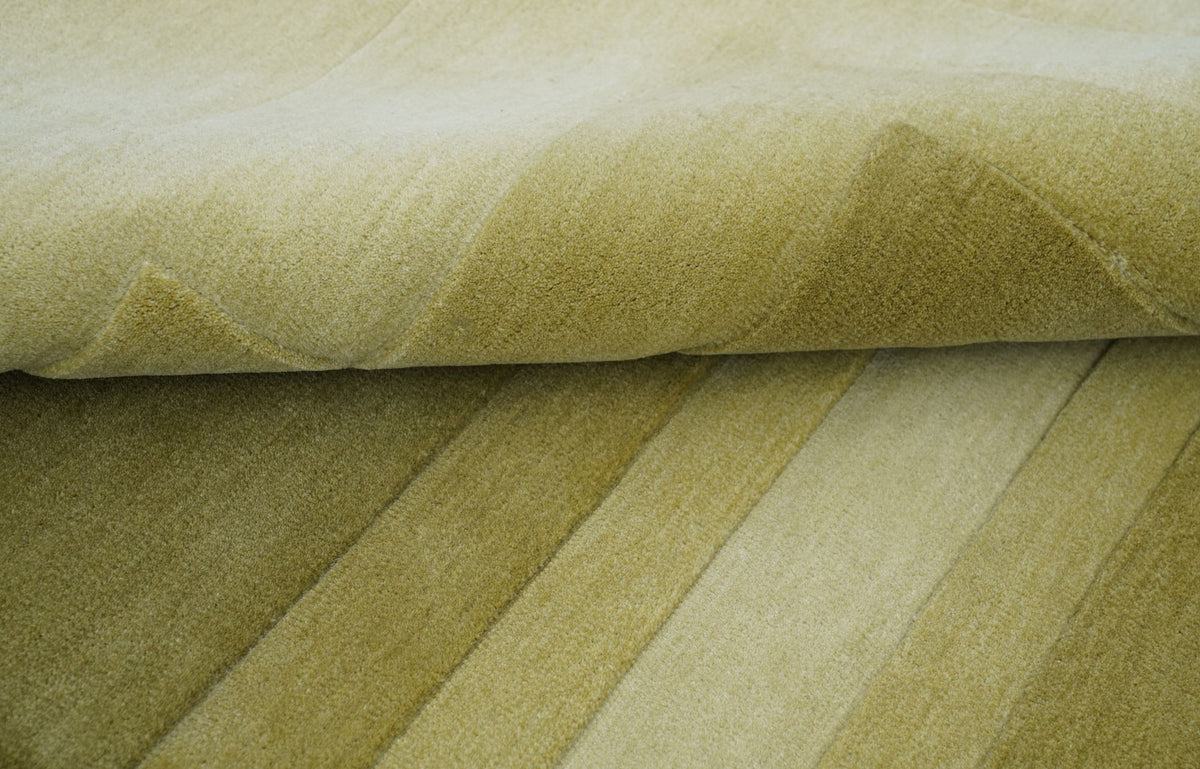 Talus Wool Rug folded in layers, hand tufted New Zealand wool in soft greens.