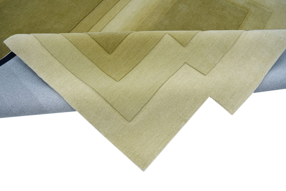 Talus Wool Rug folded at the corner, hand tufted New Zealand wool carved into stepped layers of moss and olive.