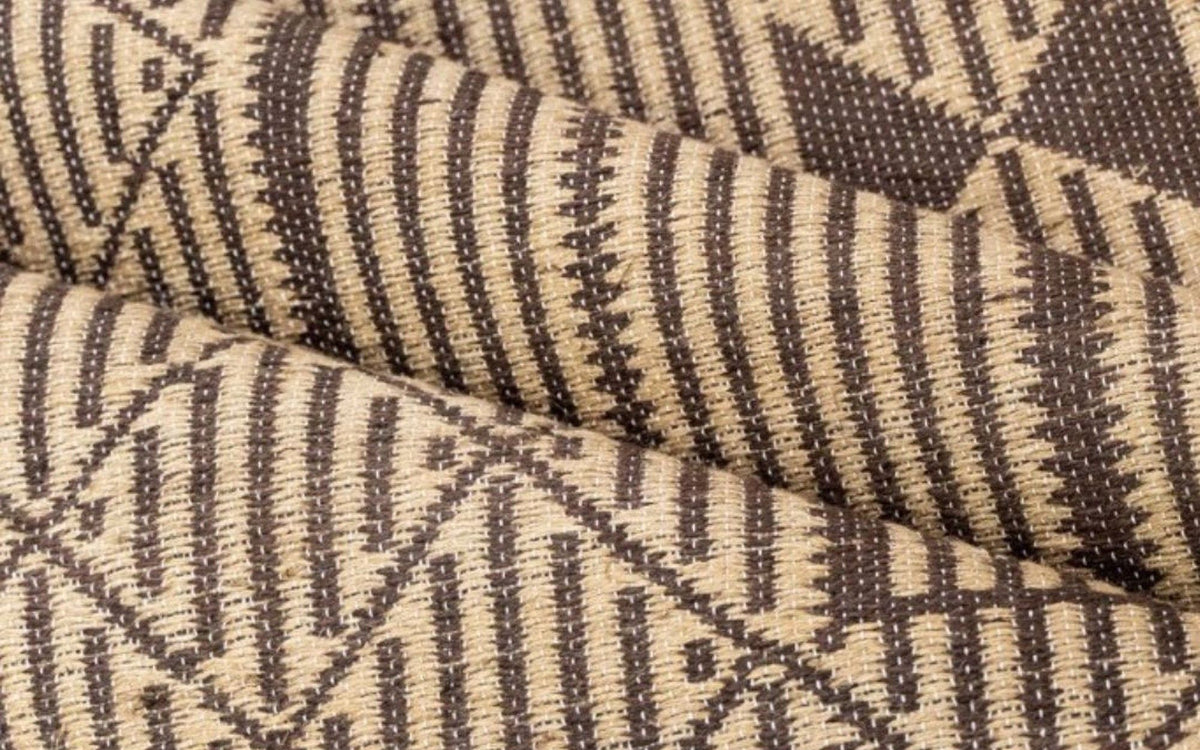Masai Jute Rug folded, handwoven natural jute with dark brown stripes and small triangles.