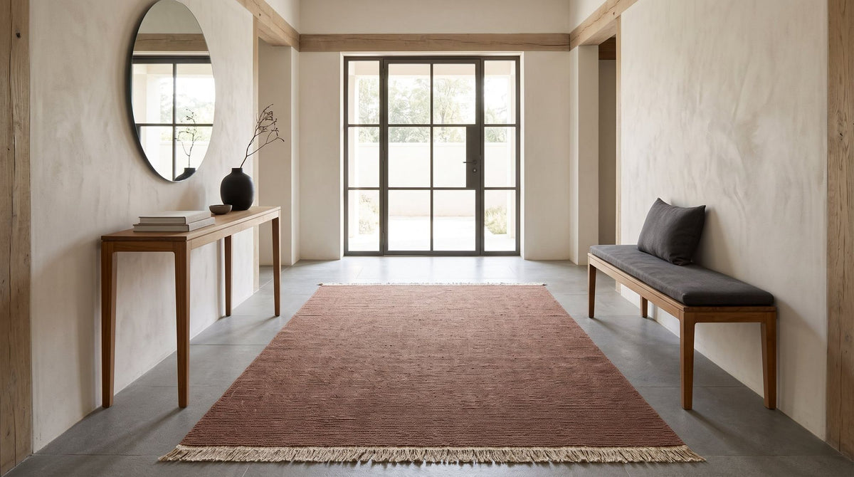 Cabra Wool & Jute Rug in Rust, handloom wool and jute, at the entrance of a home. Room is a digital render; the rug is from a product photo.