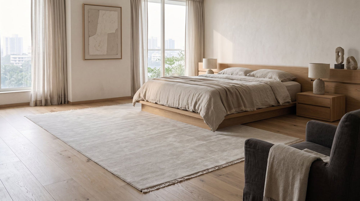 Cashmere Blend Rug in Salt, handloom wool and cashmere blend, beside the bed. Room is a digital render; the rug is from a product photo.