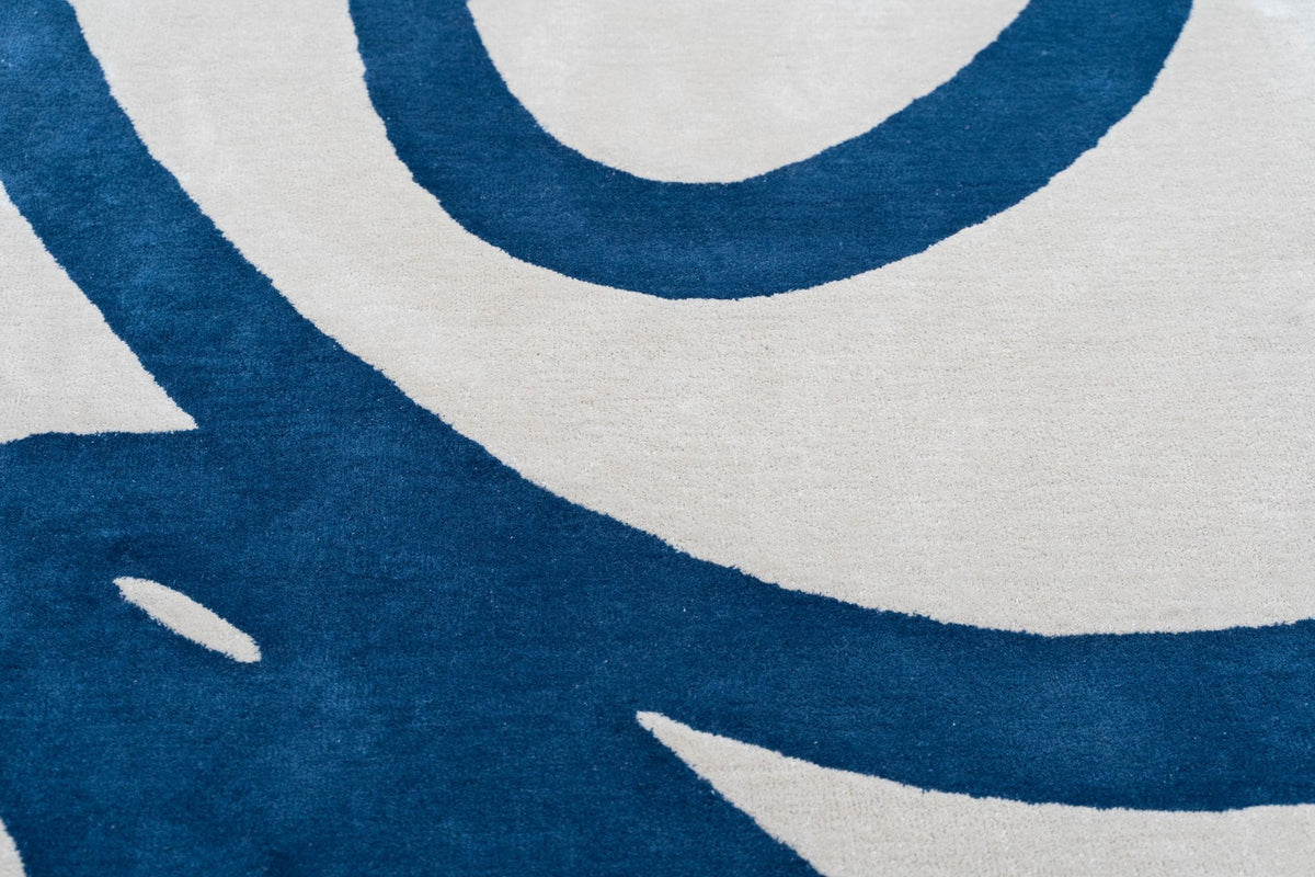 Bedlam Wool Rug close up, a deep blue curve cut into ivory hand tufted New Zealand wool.