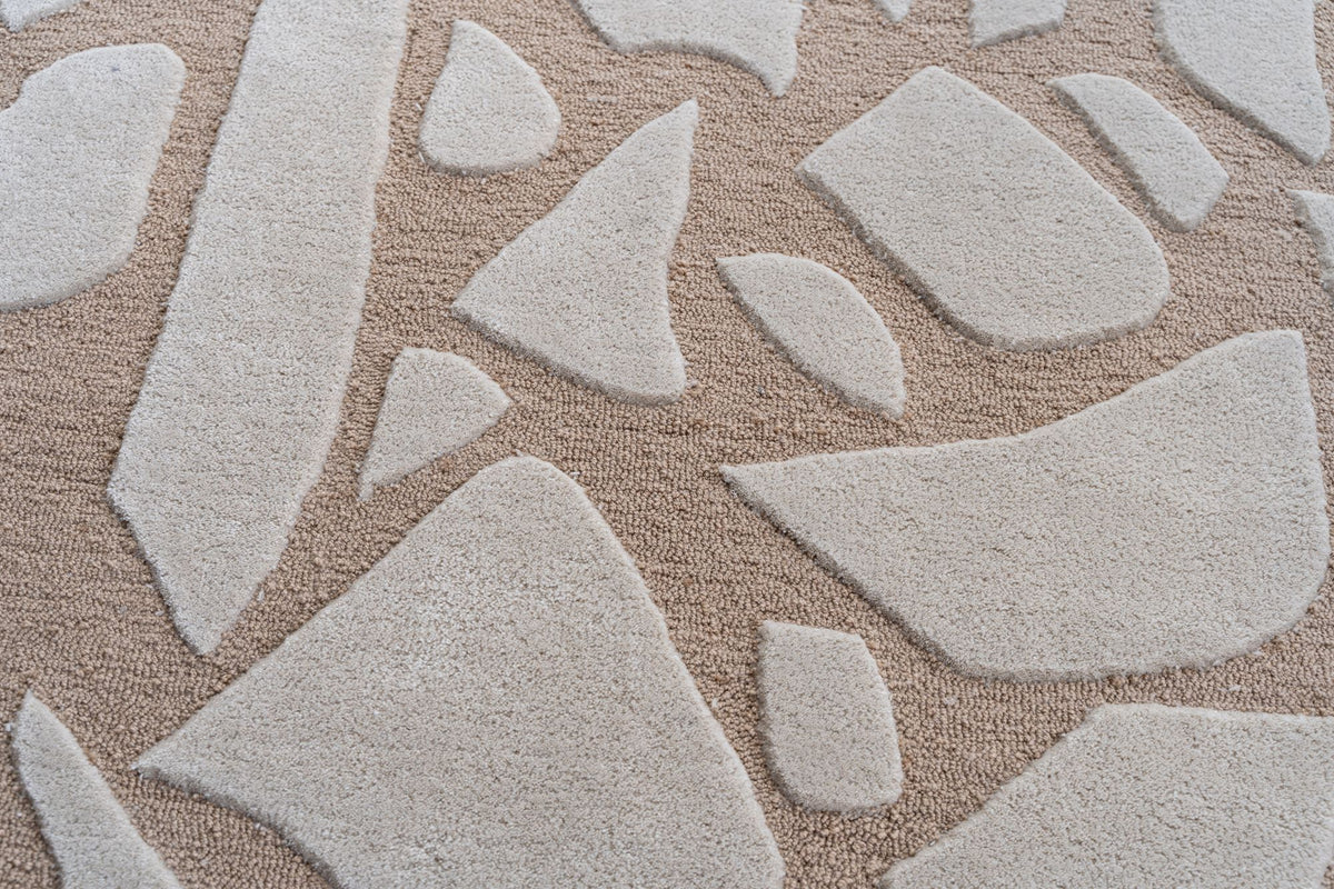 Bergamo Rug close up, ivory fragments in hand tufted New Zealand wool on a warm sand ground.