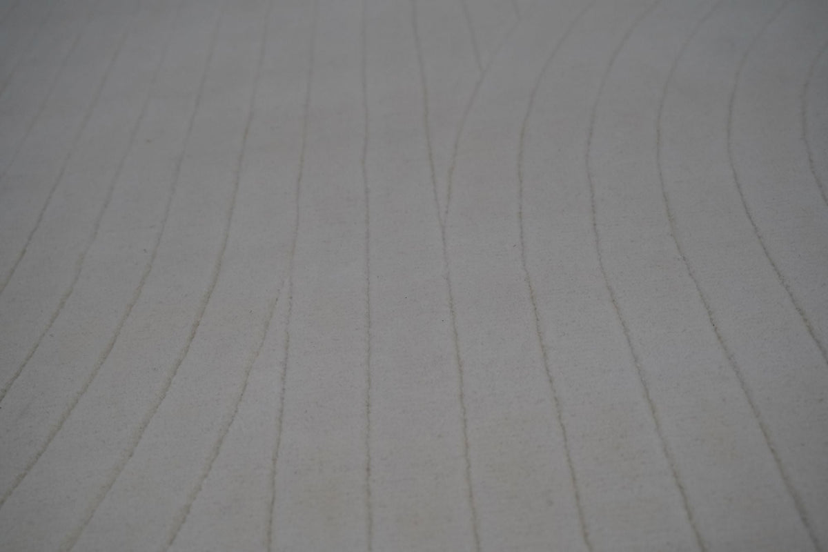 Bitte Wool Rug close up, hand tufted New Zealand wool with fine marks running across a grey ground.
