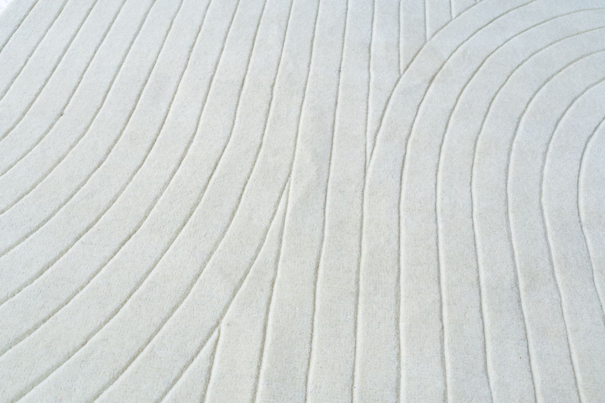 Bitte Wool Rug, a real close up of arcs and lines cut into a single tone of hand tufted New Zealand wool, the same quiet geometry Round Square uses.