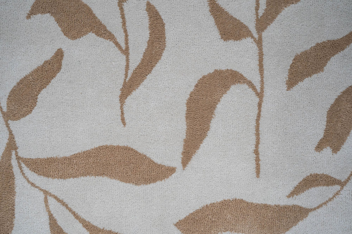 Botanical Wool Rug close up, hand tufted New Zealand wool with tan leaf sprays on an ivory ground.