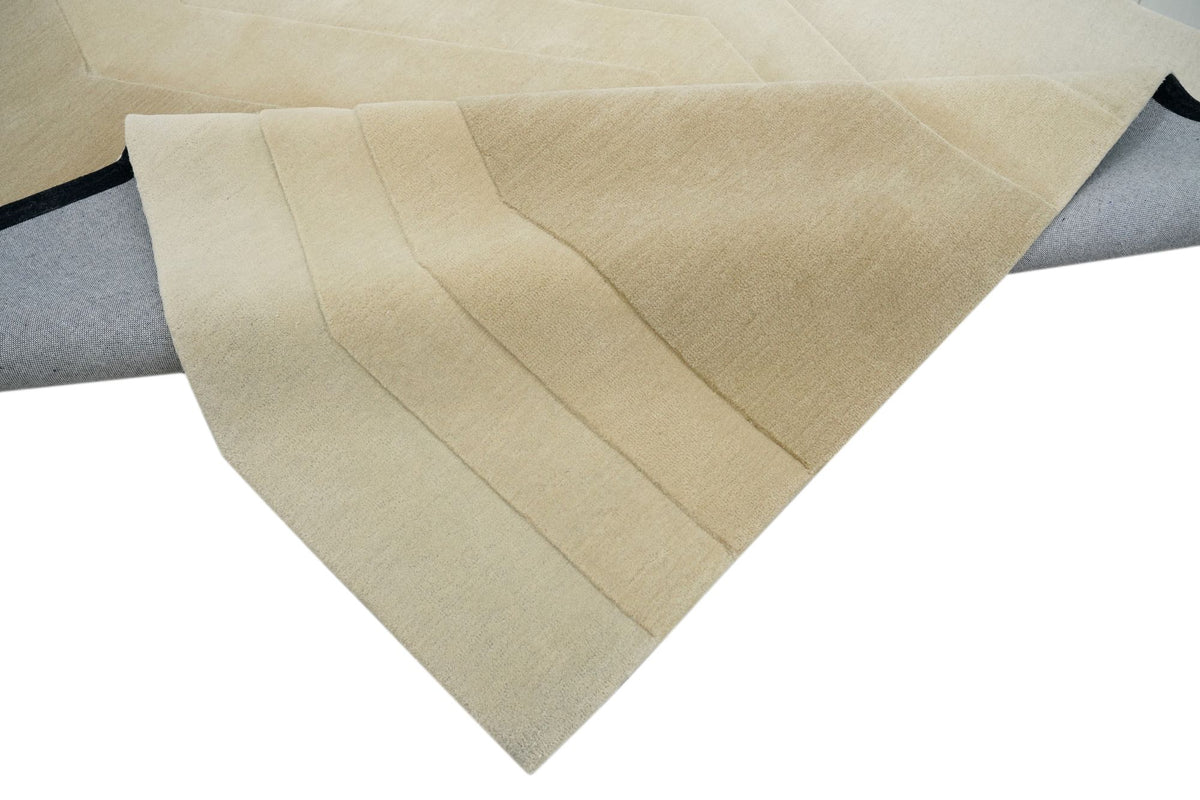 Cadence Wool Rug folded at the corner, hand tufted ivory New Zealand wool with stepped bands.
