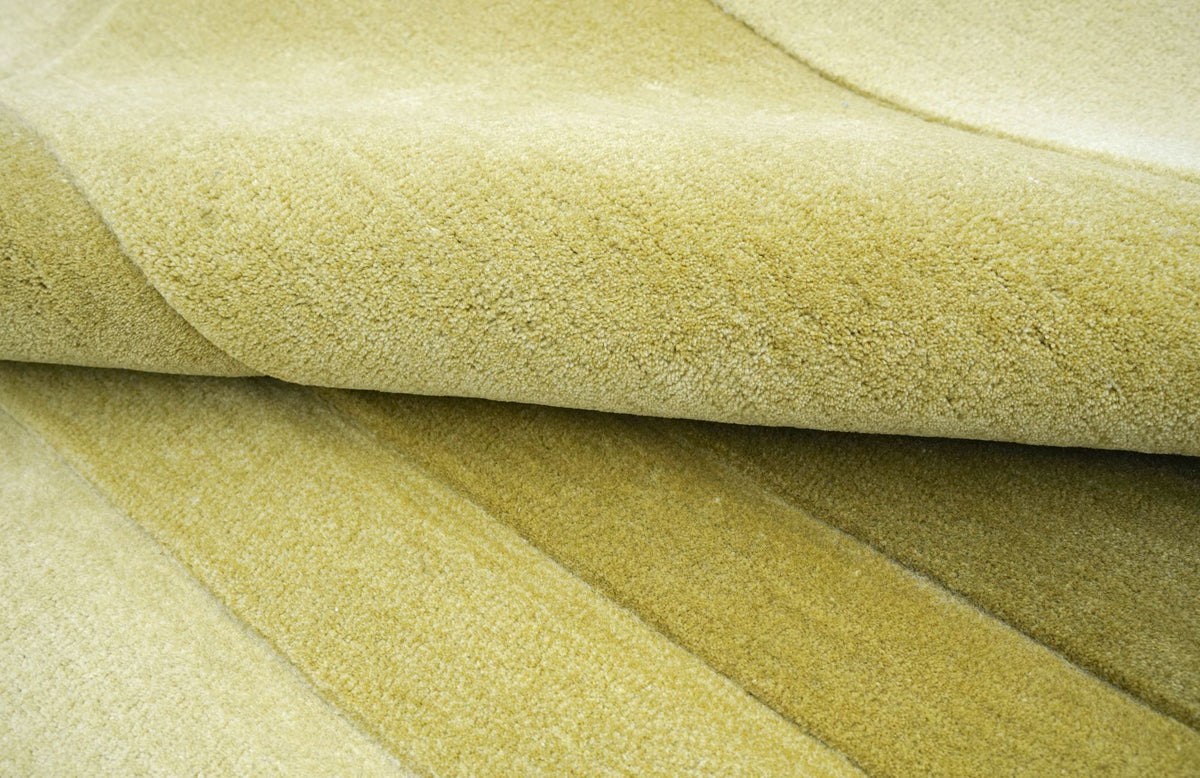 Cavea Wool Rug close up, hand tufted New Zealand wool in green tones with carved edges.