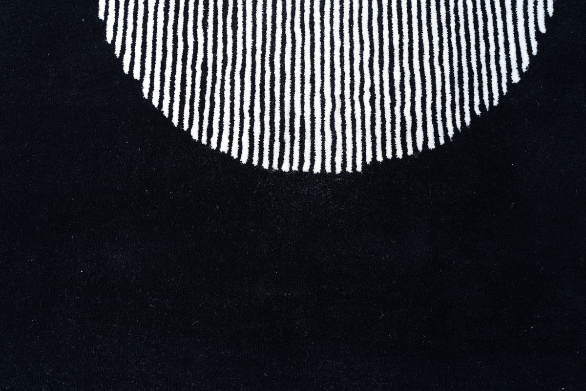 Clique Wool Rug in Pitch Black close up, a fan of fine ivory lines on black hand tufted New Zealand wool.