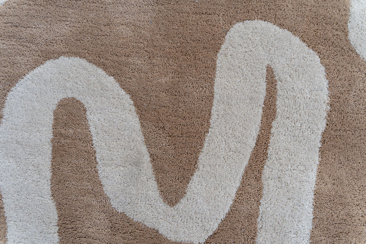 Congrand Wool Rug close up, hand tufted New Zealand wool in camel with loose ivory lines drawn across it.