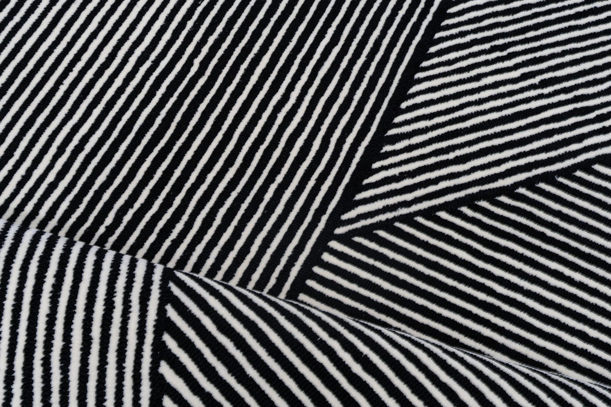 Flair Wool Rug close up, dense black and ivory stripes in hand tufted New Zealand wool that break up crumbs and marks.