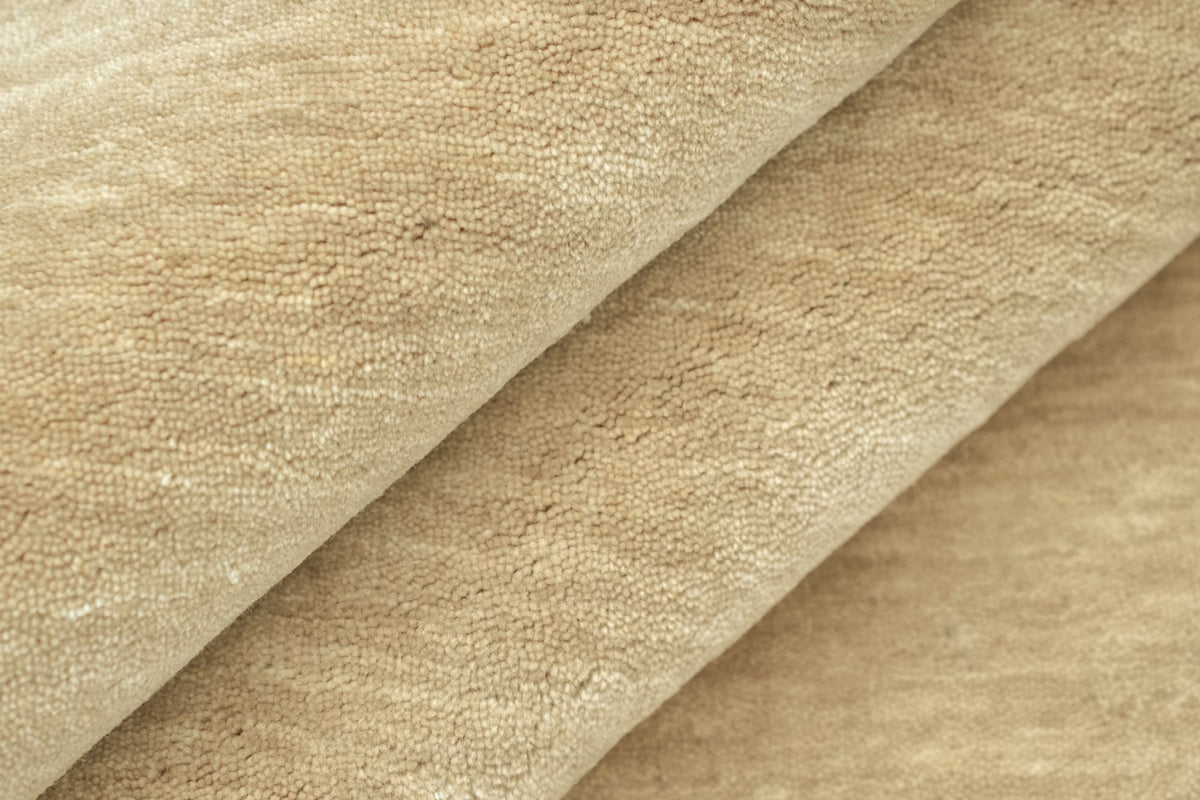 Grain Wool Rug in Sandstone folded at the corner, the low, closely worked handloom weave of New Zealand wool.