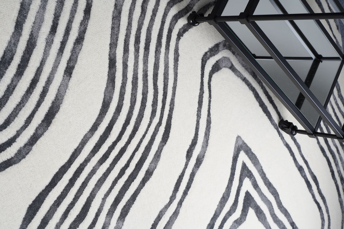 Livid Wool & Silk Rug styled beside a black metal stair, hand tufted New Zealand wool and Botanical Silk.