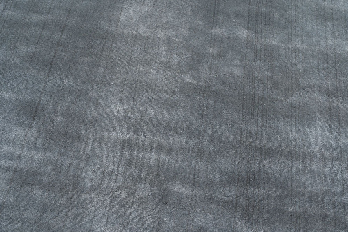 Luma Silk Rug in Charcoal close up, handloom Botanical Silk with a soft, shifting sheen in dark grey.