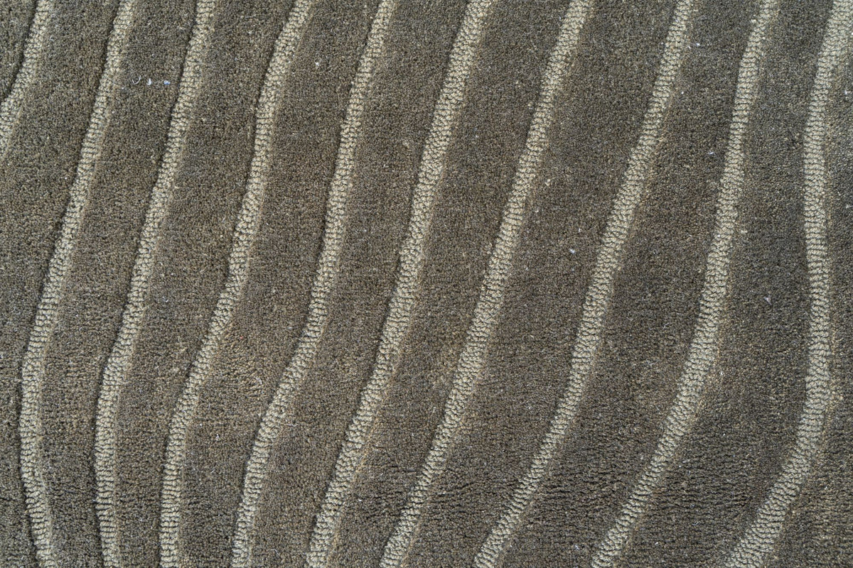 Moss Wool Rug close up, hand tufted New Zealand wool in soft green carved with long wavy lines.