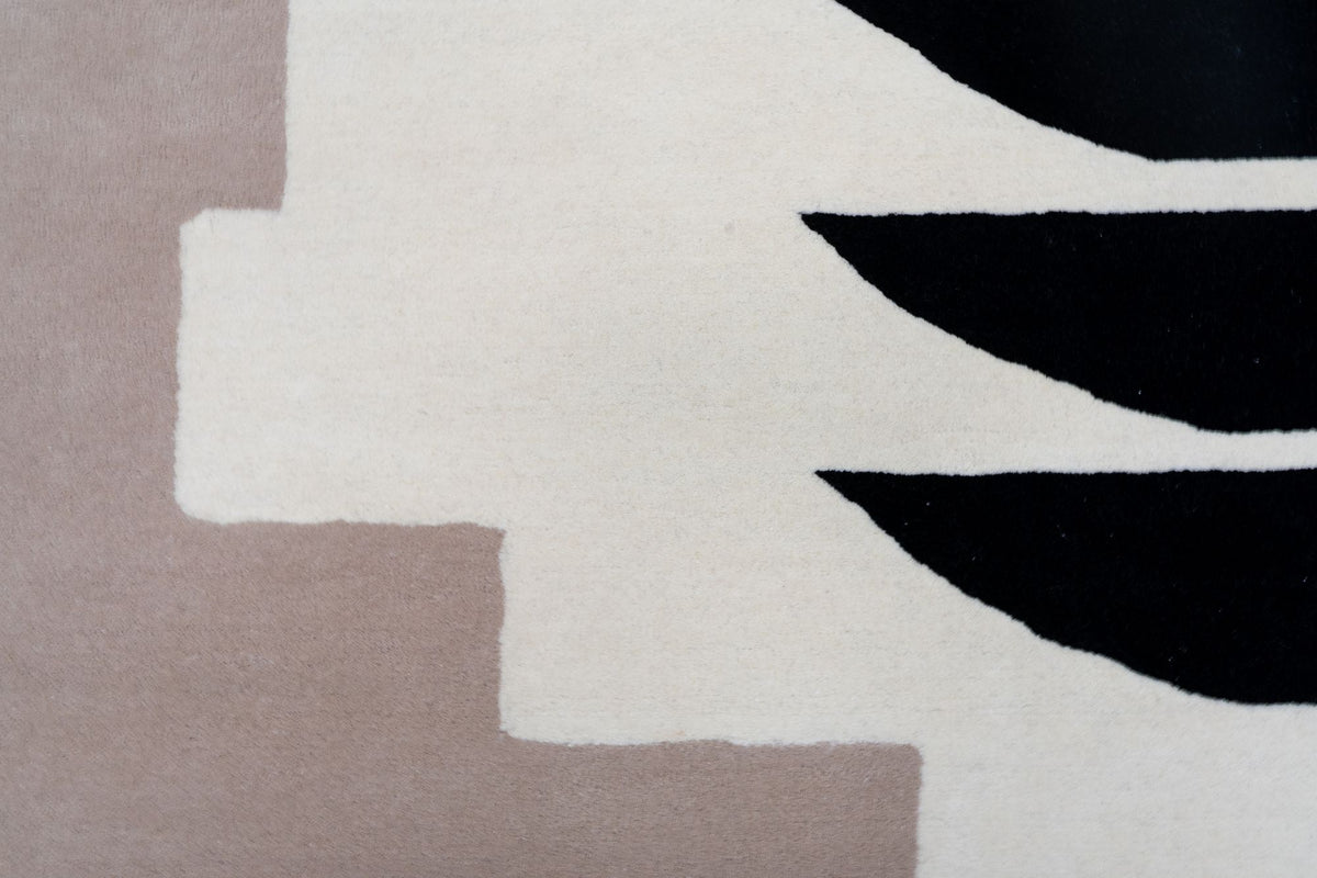 Murasaki Wool Rug close up, ivory hand tufted New Zealand wool with stepped planes of soft blush taupe and black crescents.