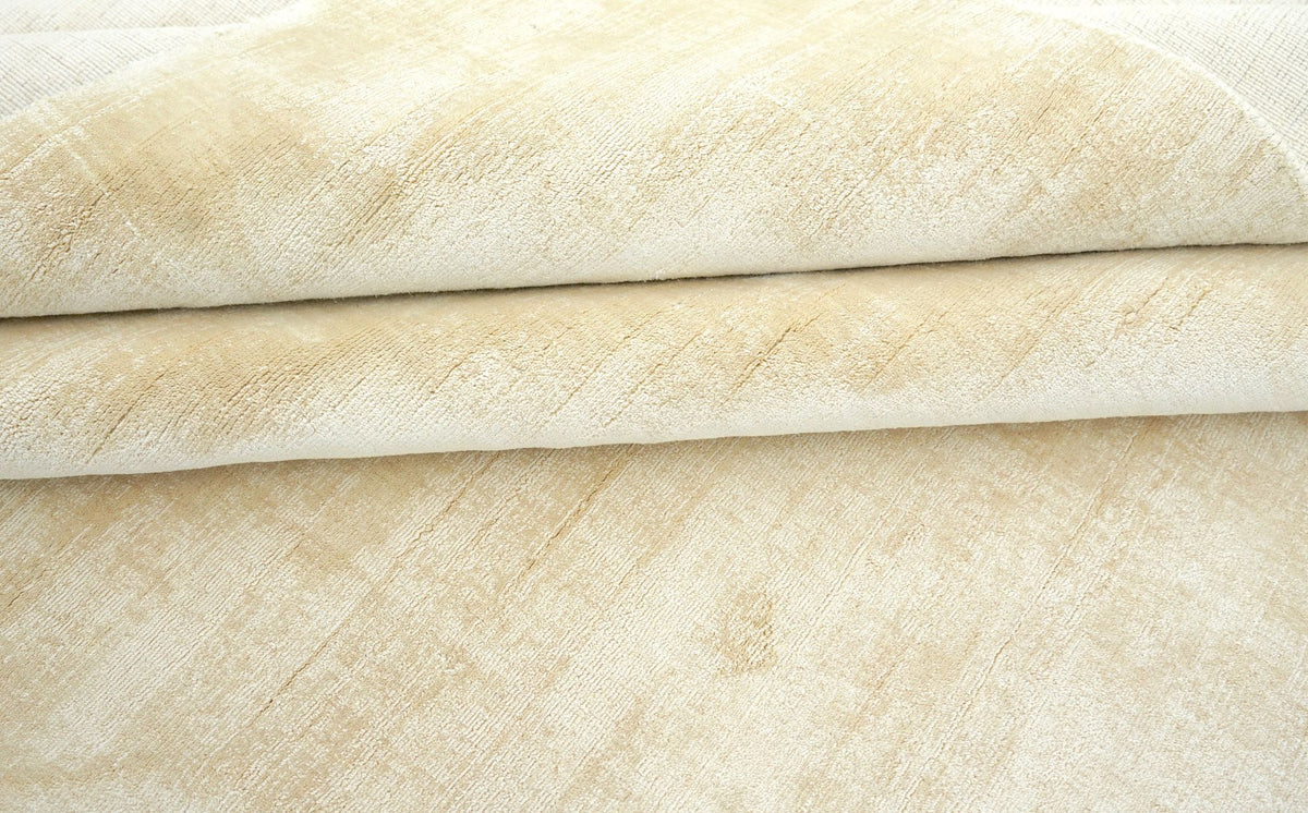 Nuva Silk Rug in Beige folded in layers, handloom silk with a pale, cloudy sheen.