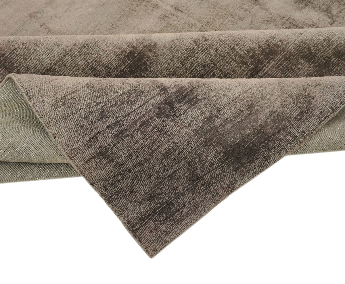 Nuva Silk Rug in Chocolate folded at the corner, showing the low handloom Botanical Silk pile and its sheen.