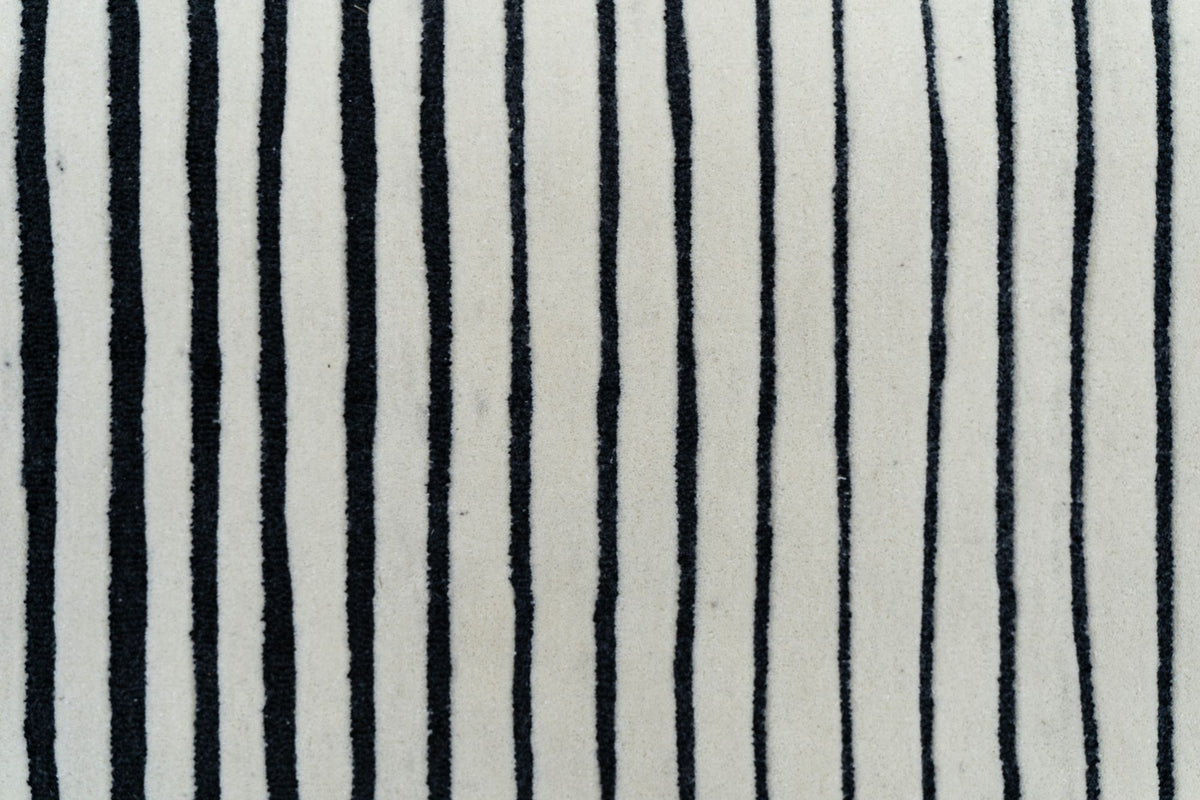 Oblique Wool Rug close up, hand tufted ivory New Zealand wool ruled with black lines.