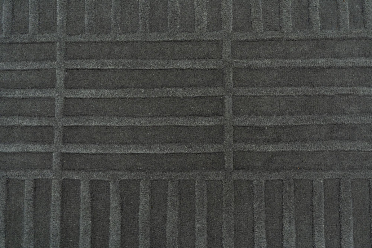 Plaid Rug close up, hand tufted grey New Zealand wool crossed by fine ivory lines.