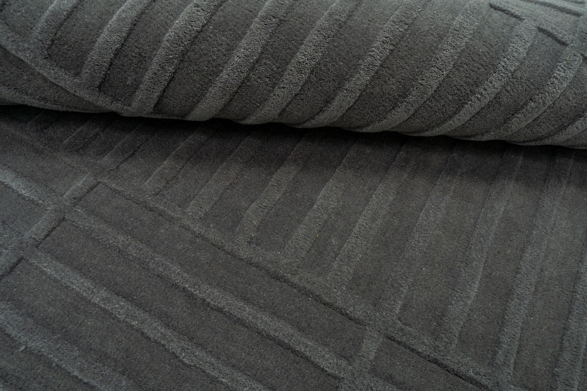 Plaid Rug close up, hand tufted New Zealand wool in charcoal with a soft carved plaid.