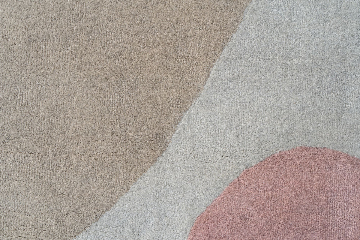 Quaint Rug close up, soft rounds of pink and grey on a sand ground in hand tufted New Zealand wool.
