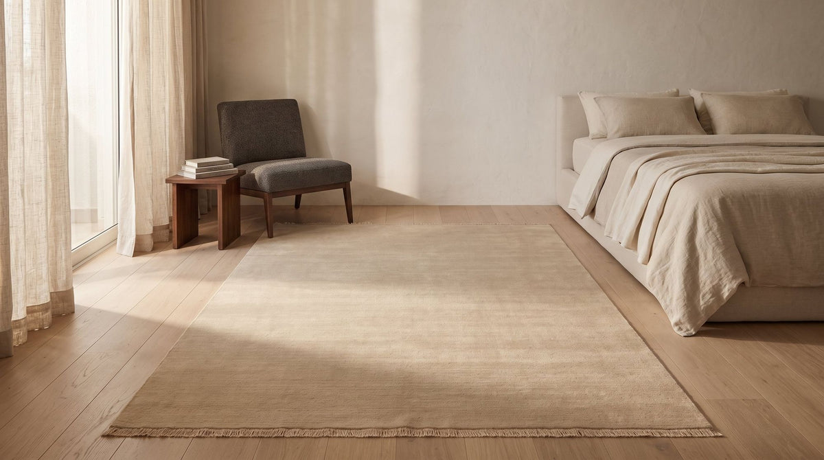 Cashmere Blend Rug in a styled bedroom render, a handloom wool and cashmere blend laid under the lower part of the bed.